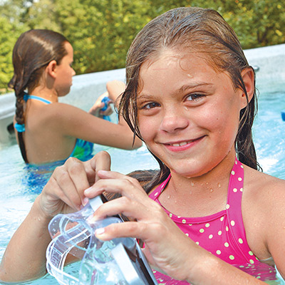 Girl smiling and holding goggles in H2X Swim spa